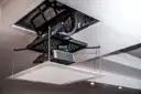 Thumbnail of A projector mounted to a motorised mechanism lowered from the ceiling